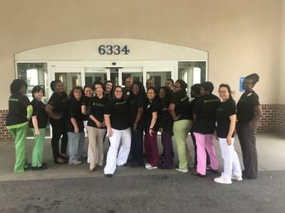 Staff members posing in front of the facility entrance