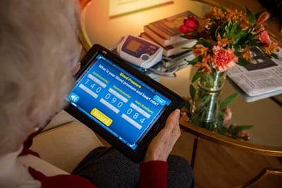 Resident using a tablet in a comfortable living area