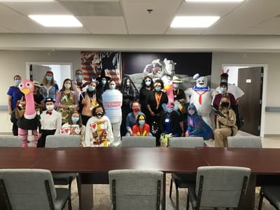 Staff and residents in costumes during a celebration