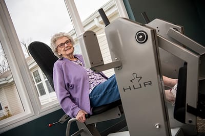 Resident using exercise equipment in a bright room