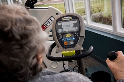 Resident using NuStep exercise equipment in a fitness area