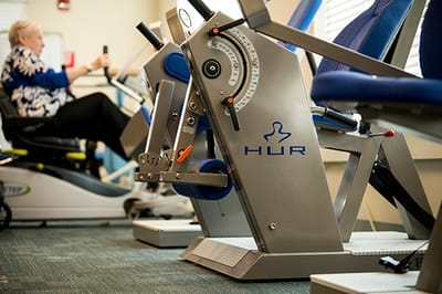 Resident engaged in physical therapy exercise equipment