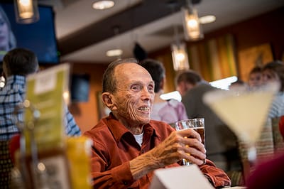 Resident enjoying a drink in a lively common area