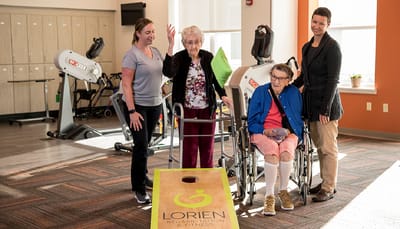 Residents engaged in an activity with staff in a fitness area