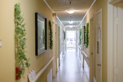Brightly lit hallway with decorative plants and artwork