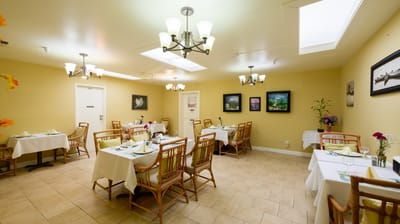 Cozy dining room with tables set for residents