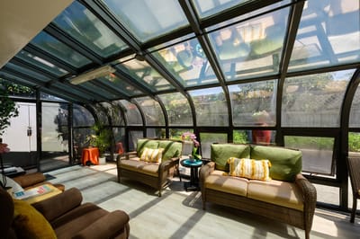 Bright sunroom with comfortable seating and greenery