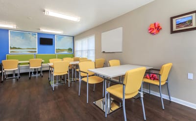 Bright common area with yellow chairs and artwork