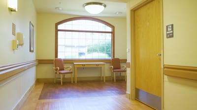 Empty hallway with chairs and a table near a window