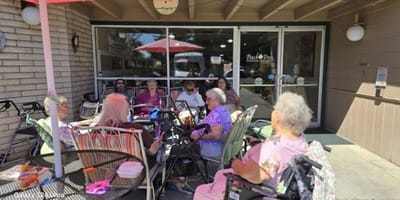 Residents enjoying time outdoors in front of the facility