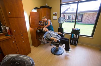 Hair salon scene with a resident receiving a haircut