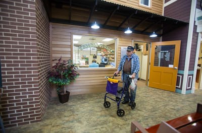 Resident using a walker in a facility hallway