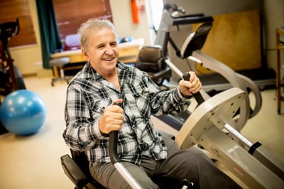 Resident using exercise equipment in a fitness area