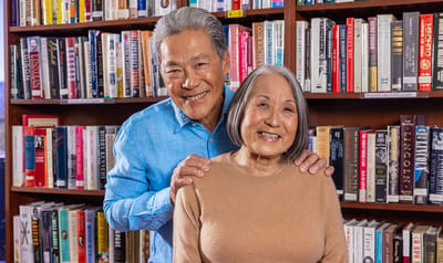 Elderly couple smiling together in a library setting