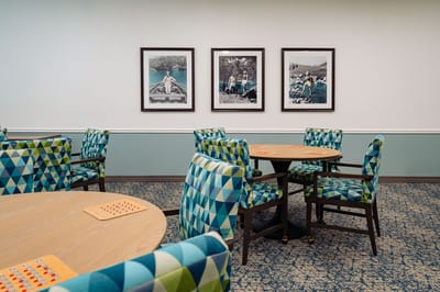 Activity room with colorful chairs and framed photos