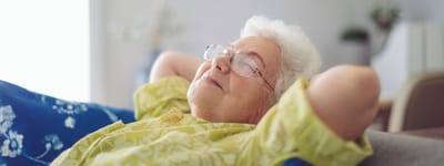 Senior resident relaxing on a couch with eyes closed