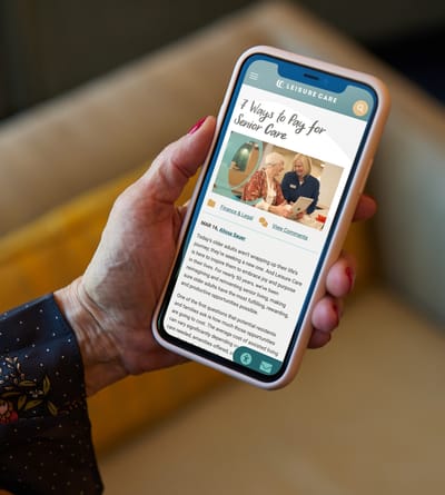 Person holding a smartphone displaying a website on senior care.
