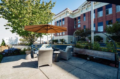 Outdoor seating area with garden and building in background