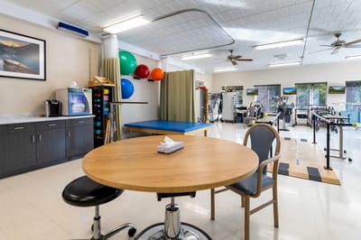 Bright rehabilitation room with equipment and seating area