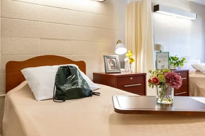 A well-decorated resident room with a bed and flowers