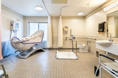 Bright and clean assisted bathing room with specialized equipment