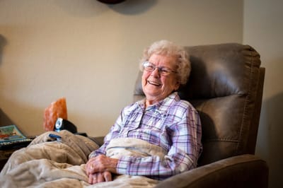 Smiling senior woman seated comfortably in a chair