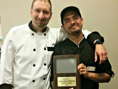 Chefs posing with a trophy from a baking competition