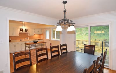 Interior dining room with large wooden table and outdoor view