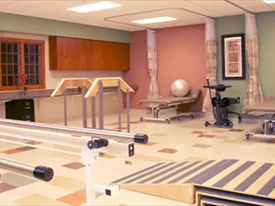 Physical therapy room with equipment and therapy bars