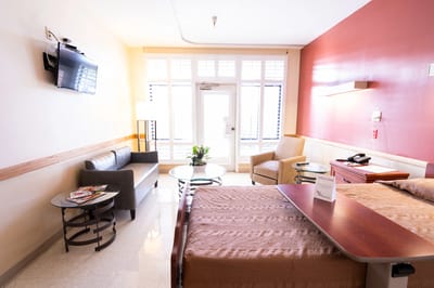 Comfortable resident room with seating area and TV