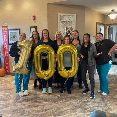 Staff celebrating with balloons marking a milestone