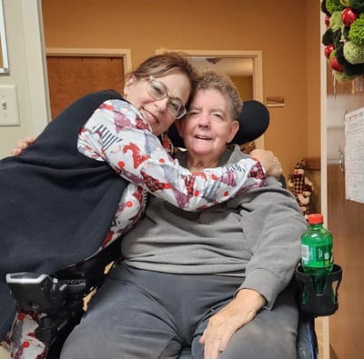 Staff member embracing a resident in a cozy lobby