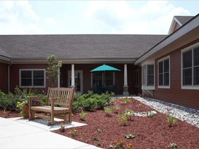 Outdoor area with a bench and flowers in front of the building