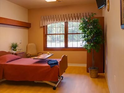 A private resident room with a bed and window