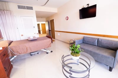Comfortable resident room with a couch and bedside table