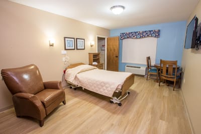 A cozy resident room with a bed and seating area