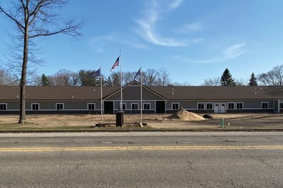 Exterior view of the facility with flags and landscaping