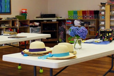 Common area with craft supplies and straw hats.