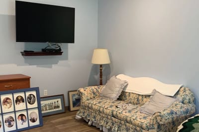 Cozy living area with floral sofa and TV.