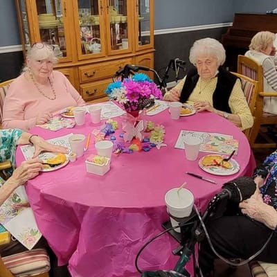Residents enjoying a meal together at a festive table.