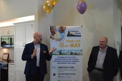Two men in a common area with a promotional banner.