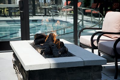 Outdoor seating by a fire pit near a pool