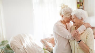 Caregiver embracing a senior resident in a bright interior