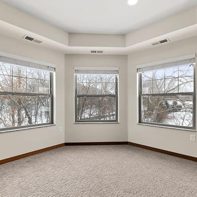 Interior view of a corner room with three windows