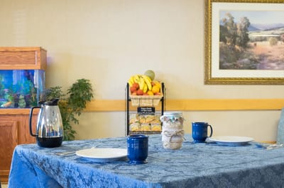 Dining table set with plates and drinks in a common area