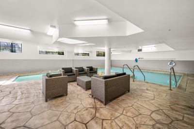 Indoor pool area with seating and natural light