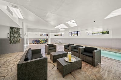 Indoor pool area with seating and natural light