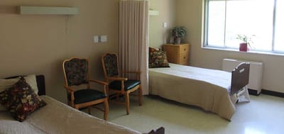 Private resident room with two beds and seating