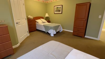 Bright private room with two beds and green walls