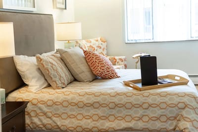 Cozy interior of a resident's room with a neatly made bed